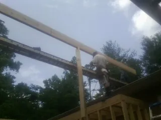 Carpenter setting a ridge beam over a new addition frame — Ice Dam Removal by Roofing Brothers in Dewar