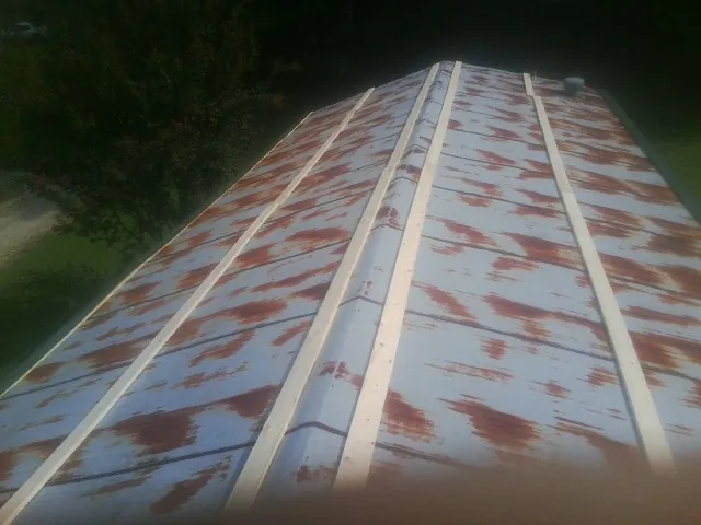 Rusted metal roof panels with new wood purlins before replacement — Storm Damage Roof Repair in Dewar by Roofing Brothers