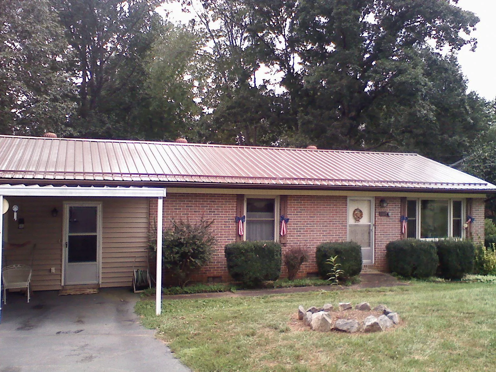 Bronze metal roof and carport on a brick ranch home — Roof Repair work by our crew in Dewar
