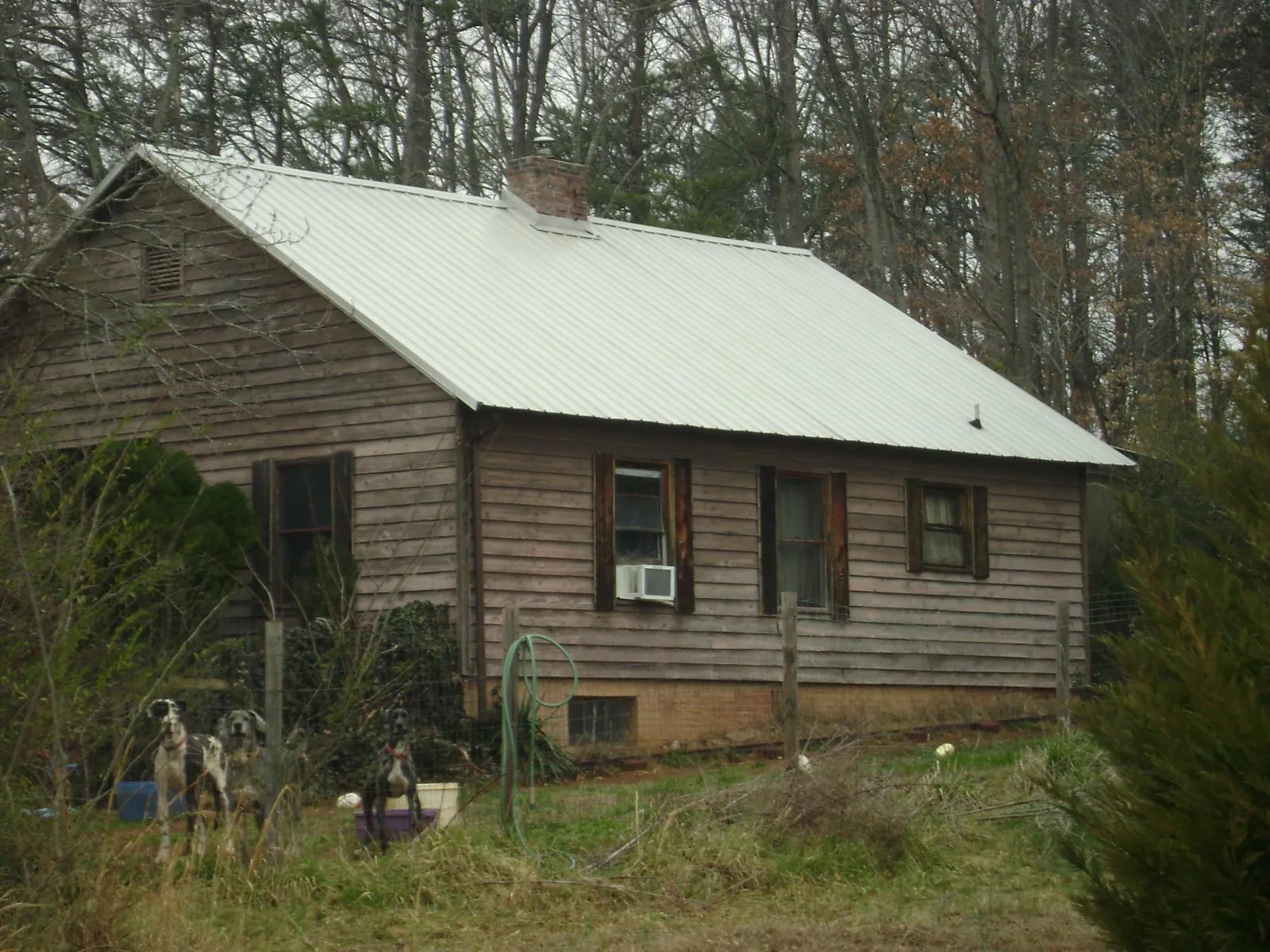 White metal roof on an old wood sided farmhouse, from a Metal Roof Installation job in Dewar